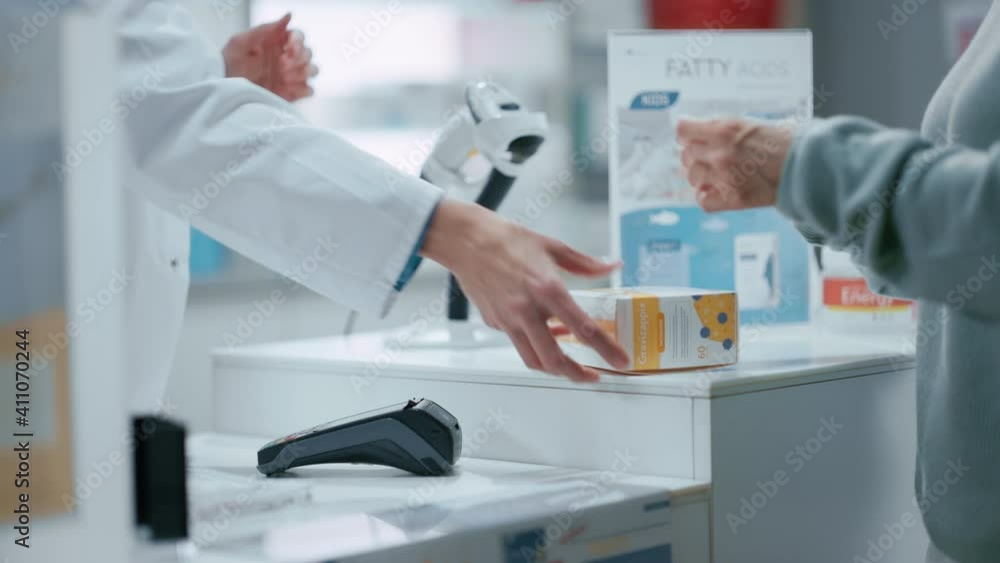Pharmacy Drugstore Checkout Cashier Counter: Pharmacist and a Customer Using Contactless Credit Card with Payment Terminal to Buy Prescription Medicine, Health Care Goods. Close-up Focus on Hands Pharmacy Drugstore Checkout Cashier Counter: Pharmacist and a Customer Using Contactless Credit Card with Payment Terminal to Buy Prescription Medicine, Health Care Goods. Close-up Focus on Hands