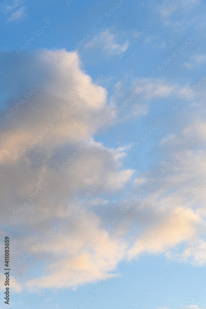 Late afternoon cloudscape, glowing clouds against a blue sky, as a nature background
