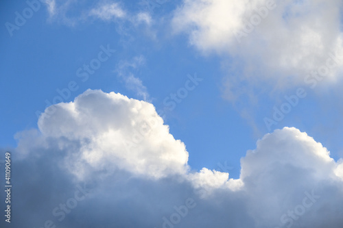 Dramatic and glowing cloudscape of blue sky and white and gray clouds as a nature background 