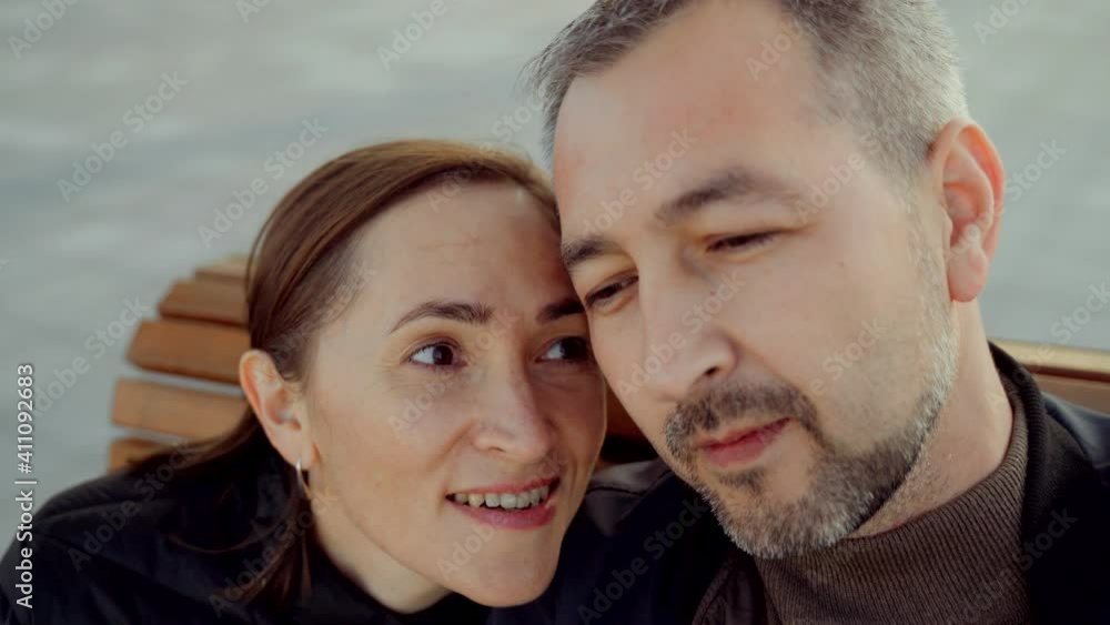 An adult couple whirling on a carousel filming themselves on camera. An adult couple whirling on a carousel filming themselves on camera.
