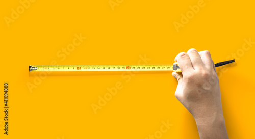 The person is using the length meter, tool for measuring length, Isolated on yellow background and clipping path.