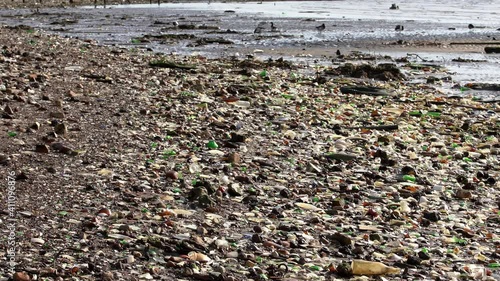 Massive amount of Trash on Beach on Atlantic Ocean. Polluted Beach. Rubbish and discarded Glass and Plastic on Sand Beach in New York, USA