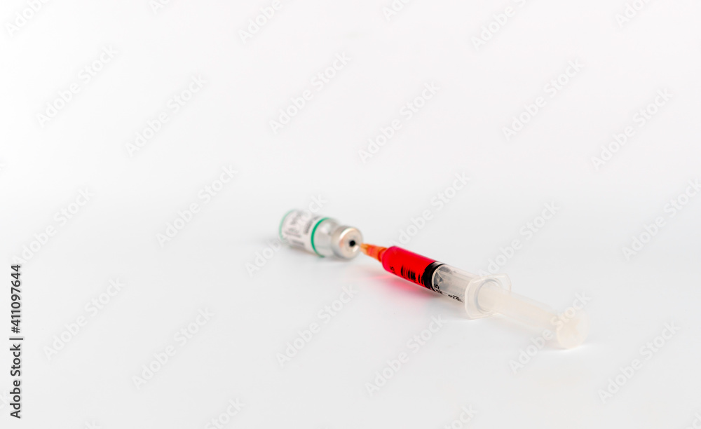 Syringe in a Allergen immunotherapy bottle. Corona virus vaccine, Health technology concept, syringe and a bottle isolate on white background with selective focus. Syringe in a Allergen immunotherapy bottle. Corona virus vaccine, Health technology concept, syringe and a bottle isolate on white background with selective focus.