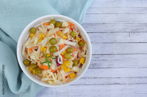 Salad of fresh cabbage with green peas and corn.