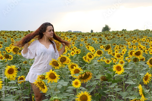 Girl in a white dress in a field of sunflowers