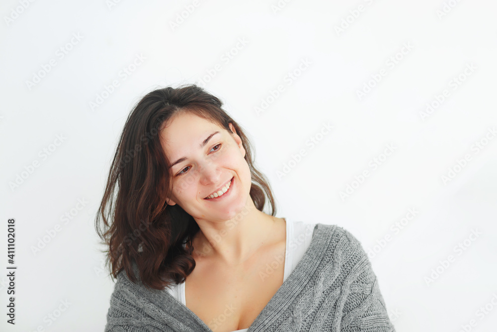 curly woman in gray knitted sweater on bright background curly woman in gray knitted sweater on bright background