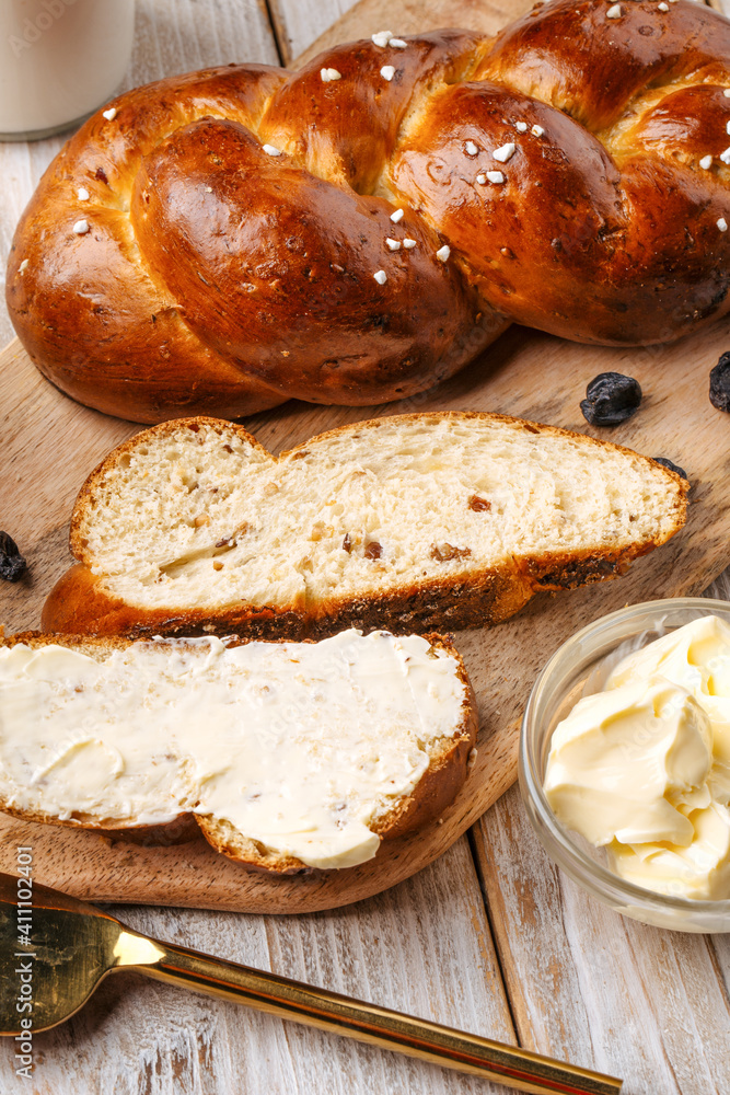 Top view on sweet raisins bun pigtail bread on the decorated wooden background Top view on sweet raisins bun pigtail bread on the decorated wooden background