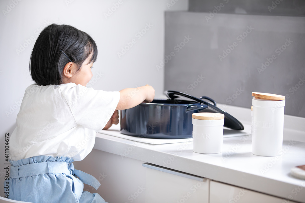 白いキッチンで女の子が青い鍋で料理をしている　girl kitchen 