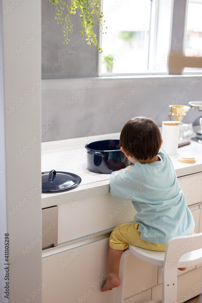 白いキッチンで男の子が青い鍋で料理をしている　boy kitchen 