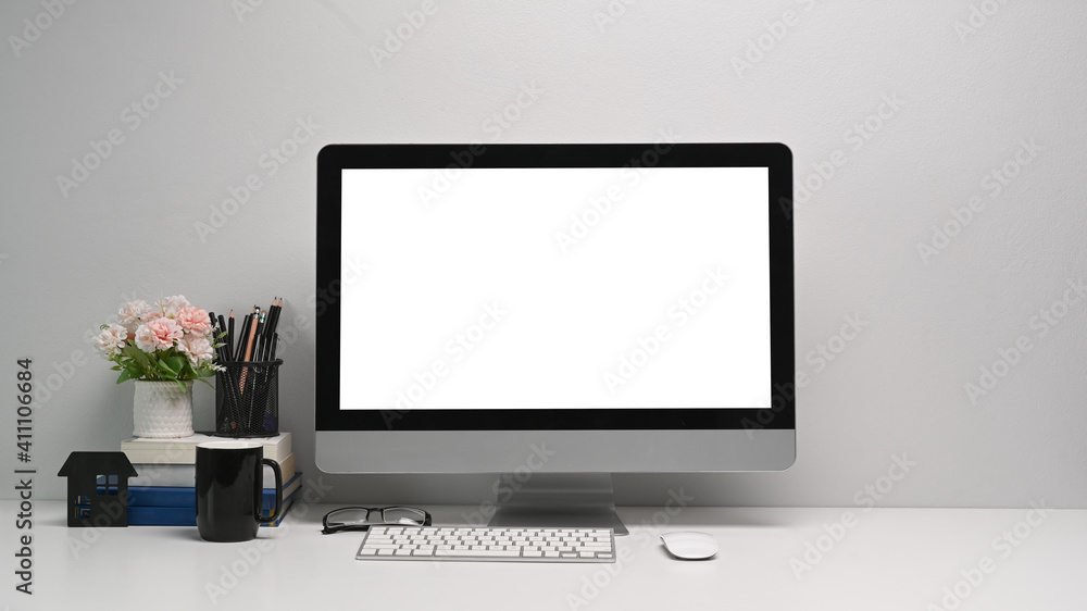 Front view of simple workspace with modern computer and office supplies. Blank screen for your text or advertising content Front view of simple workspace with modern computer and office supplies. Blank screen for your text or advertising content