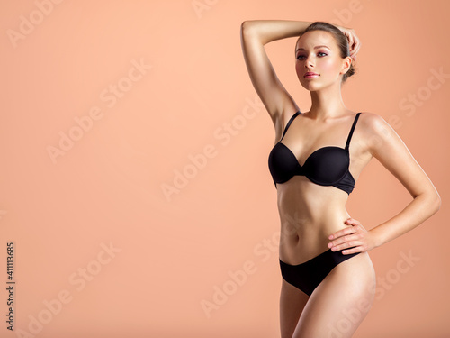 Young girl in black underwear with an ideal body, posing in the studio.