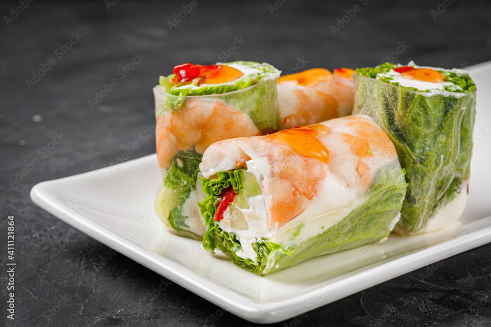 appetizing spring rolls with sea food and philadelphia cheese on a darck background appetizing spring rolls with sea food and philadelphia cheese on a darck background