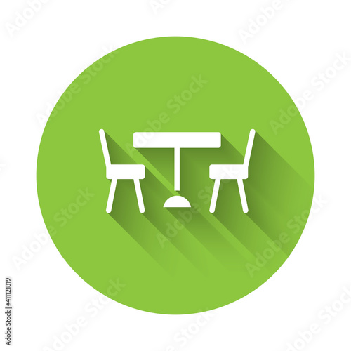 White Picnic table with chairs on either side of the table icon isolated with long shadow. Green circle button. Vector.