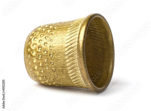 The yellow antique thimble is isolated on a white background.