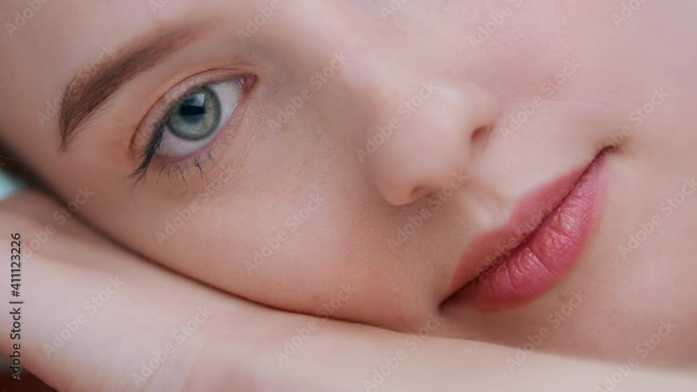 Detail of young woman laying on her hand open eye and look at camera Detail of young woman laying on her hand open eye and look at camera