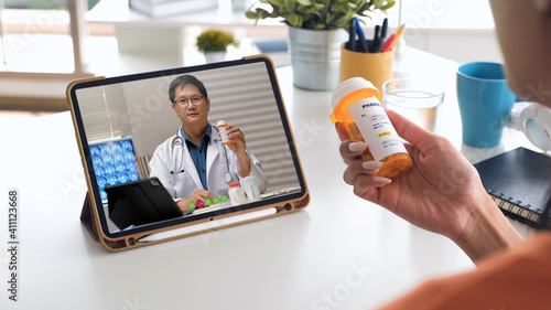 telehealth concept,asian woman video call with her doctor about prescription while staying at home. Close up of patient about illness in video conferencing with general practitioner on digital tablet. photo