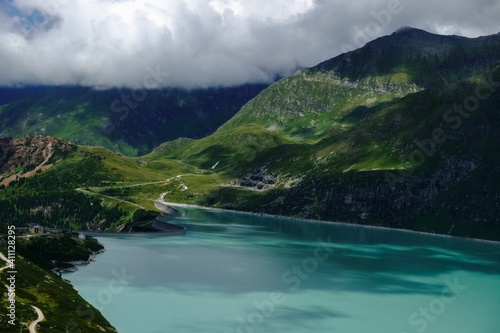 turquoise mountain lake with a curvy dam wall detail