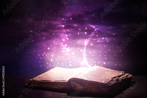 Open magic book on dark bac...