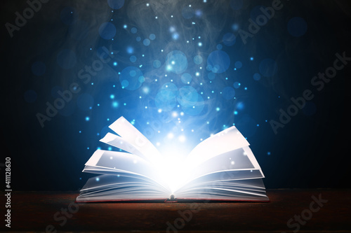 Open magic book on dark background