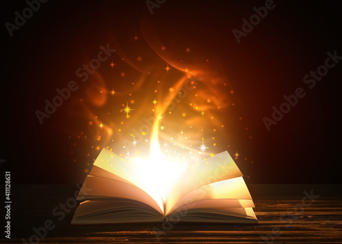 Open magic book on dark background