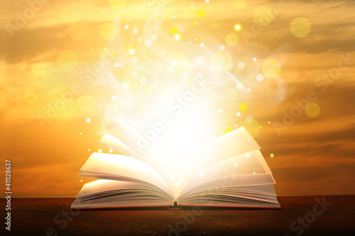 Open magic book on table ag...