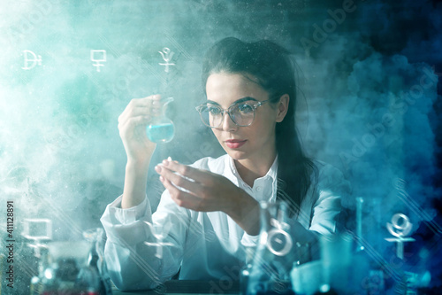 Female alchemist working in laboratory photo