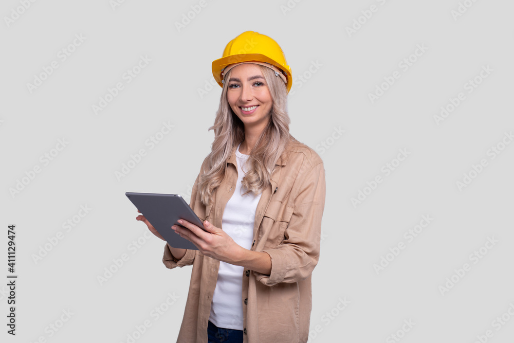 Girl Construction Worker Smilling Holding Tablet Watching Front Isolated. Girl Working with Tablet. Modern Construction, technology, Work concept Girl Construction Worker Smilling Holding Tablet Watching Front Isolated. Girl Working with Tablet. Modern Construction, technology, Work concept