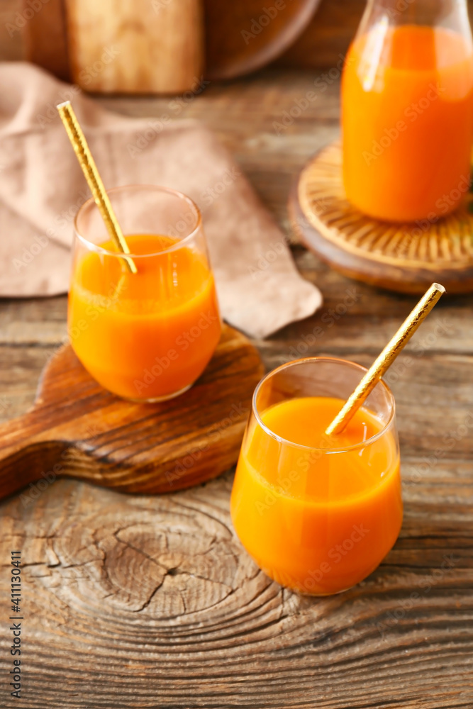 Fototapeta premium Fresh carrot juice on wooden background