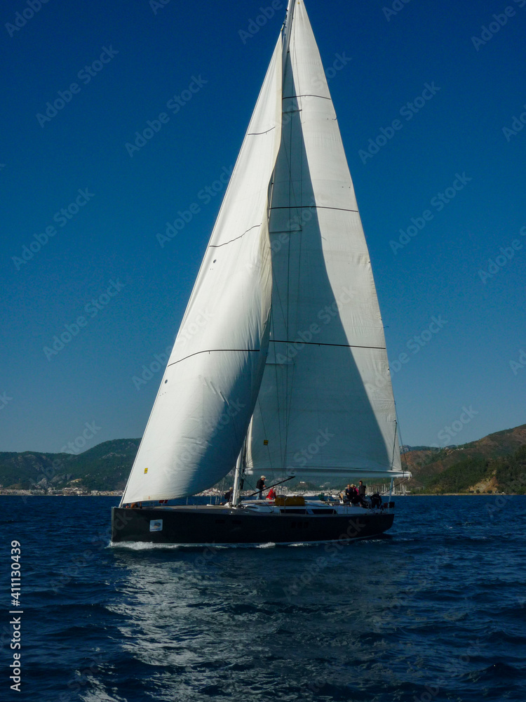 sail boat yacht in race regatta with mountain background sail boat yacht in race regatta with mountain background