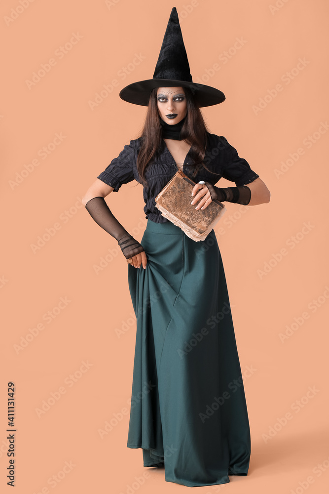 Evil young witch with spell book on color background Evil young witch with spell book on color background
