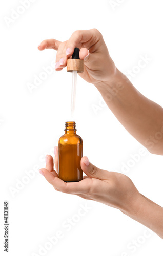 Female hands with cosmetic serum on white background