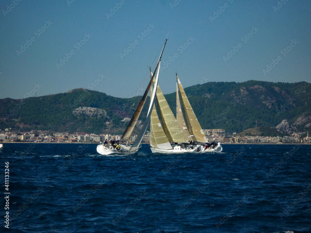 Obraz premium sail boat yacht in race regatta with mountain background