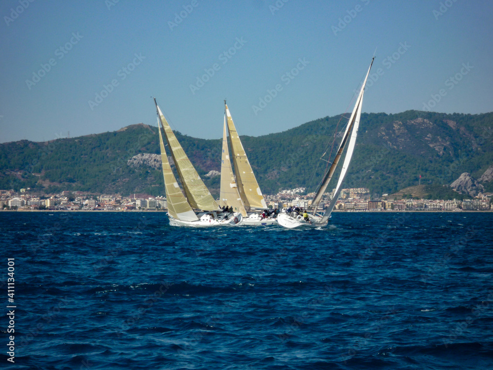 Fototapeta premium sail boat yacht in race regatta with mountain background