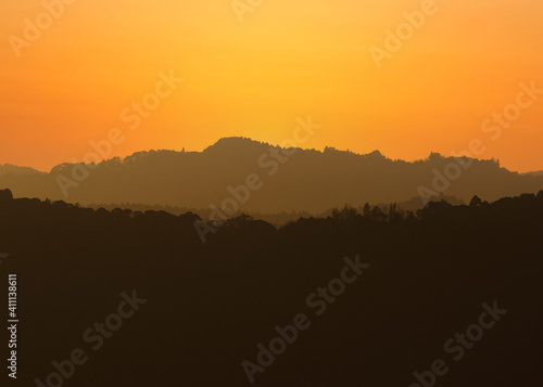 Distant hills during sunset, many layers of depth and color, from greys to orange, the place is the rolling hills in Chiba, Japan © Dane