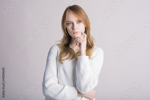 Portrait of a stylish girl on a white background in the studio who thinks