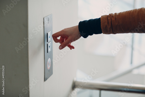 Close up of forefinger knuckle pressing the button elevator during coronavirus pandemic covid-19 quarantine concept