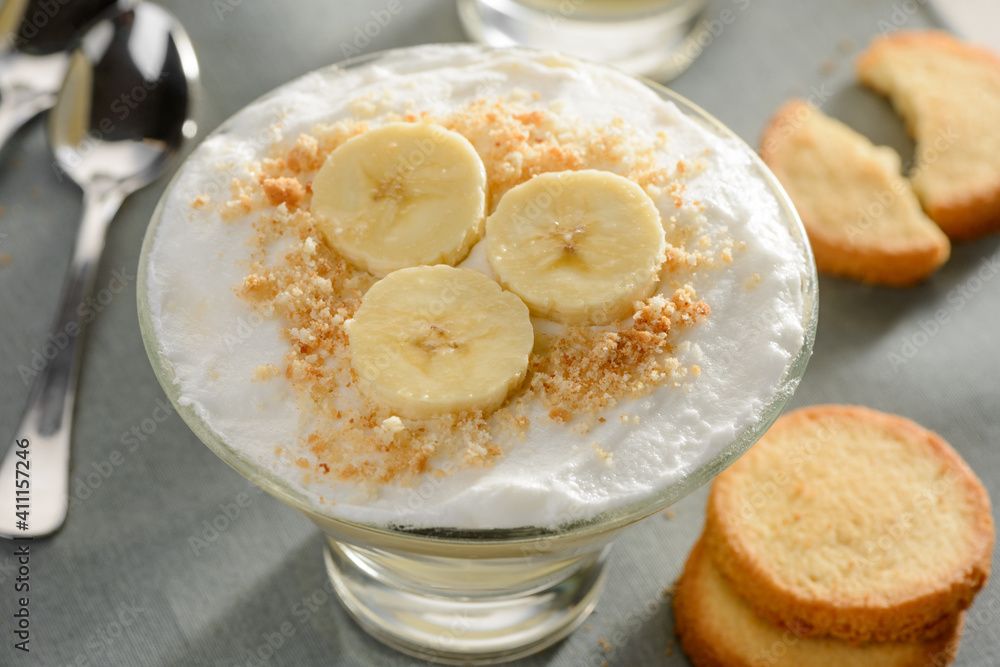 Beautiful dessert with heavy cream, banana slices and crumbed cookie