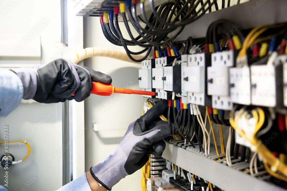 Electricians work to connect electric wires in the system, switchboard
