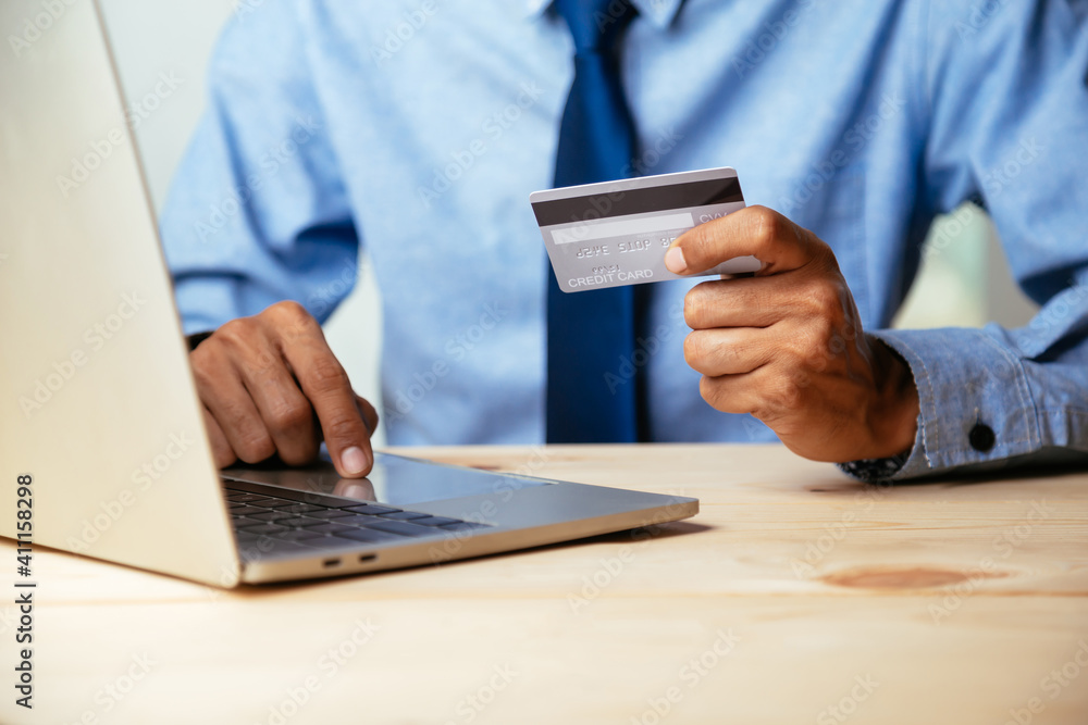 Man holding credit card and using laptop computer. Online shopping concept. Man holding credit card and using laptop computer. Online shopping concept.