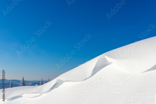 white snowdrift and blue sky. the frame is divided diagonally