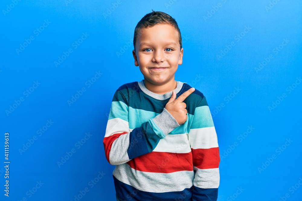 Little kid boy wearing striped sweater smiling cheerful pointing with hand and finger up to the side Little kid boy wearing striped sweater smiling cheerful pointing with hand and finger up to the side
