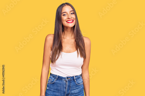 Young hispanic woman wearing casual clothes looking positive and happy standing and smiling with a confident smile showing teeth