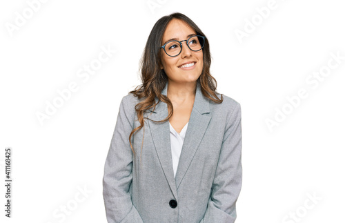 Young brunette woman wearing business clothes looking away to side with smile on face, natural expression. laughing confident.