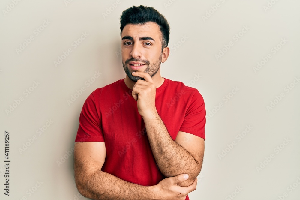 Young hispanic man wearing casual clothes smiling looking confident at the camera with crossed arms and hand on chin. thinking positive. Young hispanic man wearing casual clothes smiling looking confident at the camera with crossed arms and hand on chin. thinking positive.