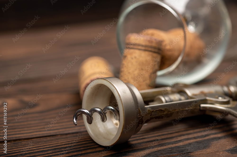 Corkscrew and corks from wine bottles on a wooden table. Corkscrew and corks from wine bottles on a wooden table.