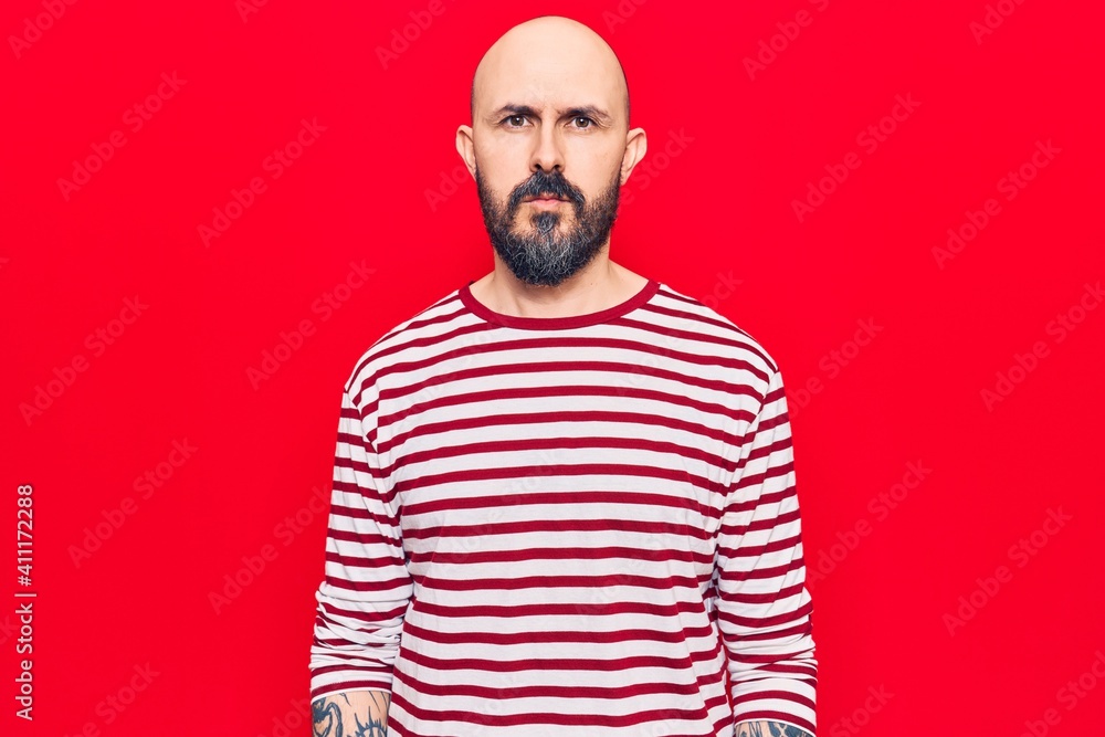 Young handsome man wearing casual clothes with serious expression on face. simple and natural looking at the camera.