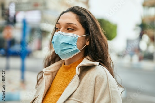 Young middle east woman wearing medical mask standing at the city.