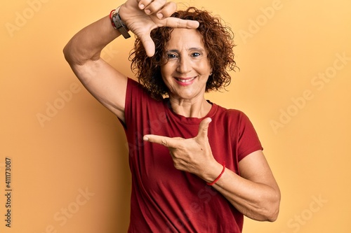 Beautiful middle age mature woman wearing casual clothes smiling making frame with hands and fingers with happy face. creativity and photography concept.