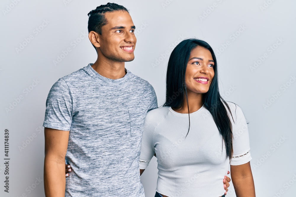 Young latin couple wearing casual clothes looking away to side with smile on face, natural expression. laughing confident. Young latin couple wearing casual clothes looking away to side with smile on face, natural expression. laughing confident.
