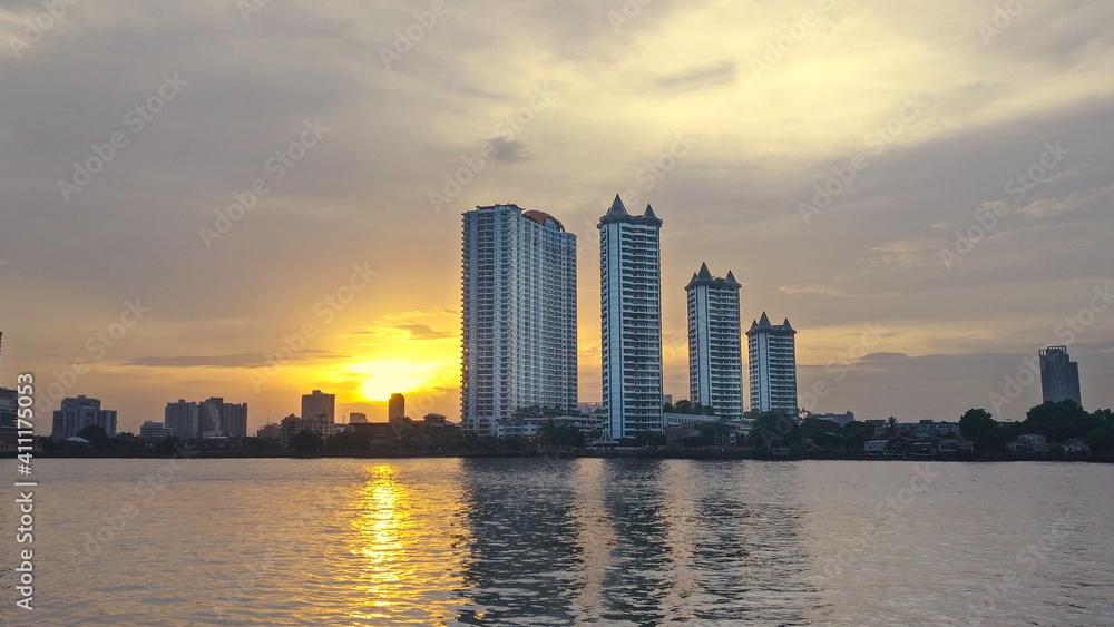Chao Phraya River - Bangkok - Thailand. Photo location is near the riverside shopping area called Asiatique. Four skyscaper in horizon and behind them beautiful sunset.